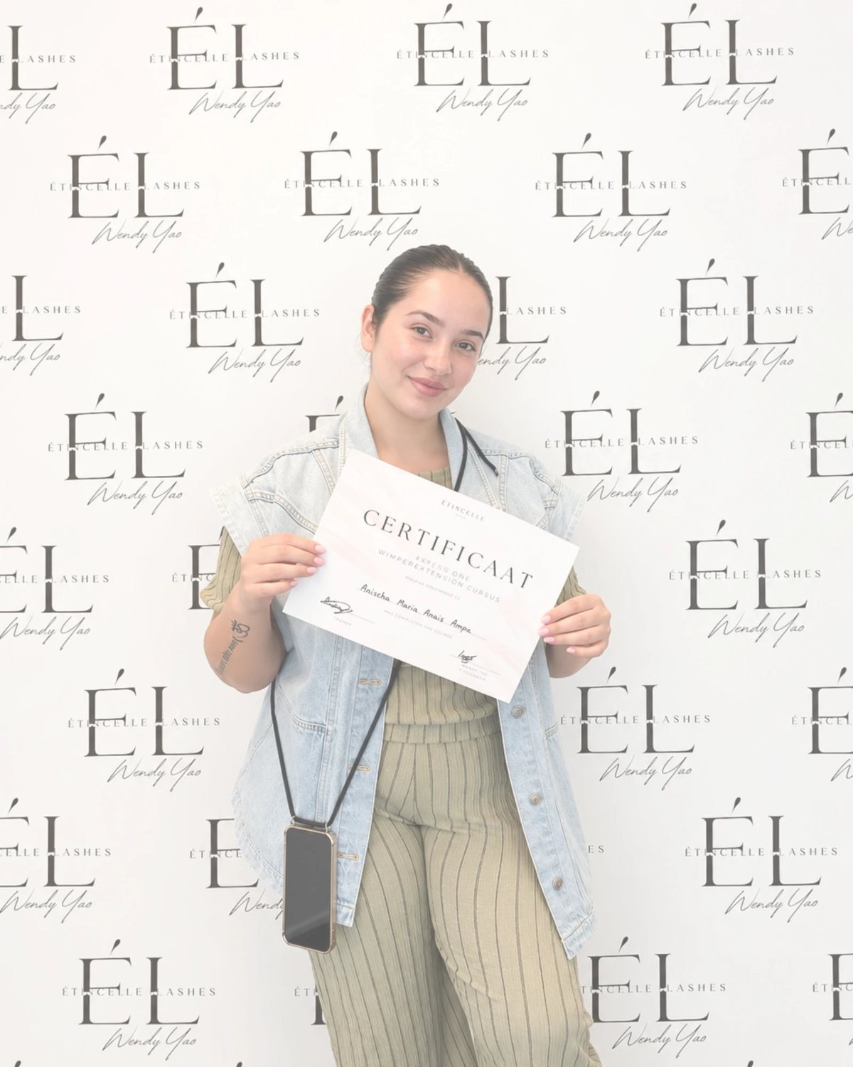 Cursist Anischa met haar certificaat voor de Étincelle Lashes wall