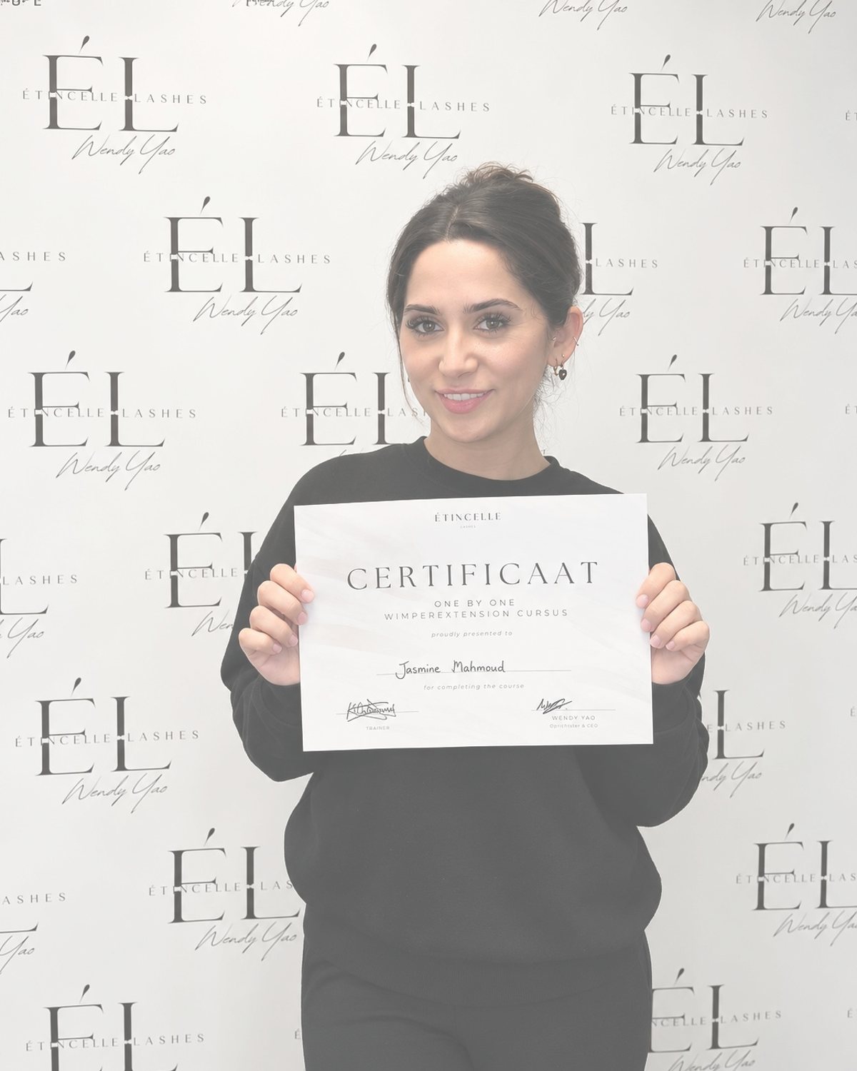 Cursist Jasmine met haar certificaat voor de Étincelle Lashes wall