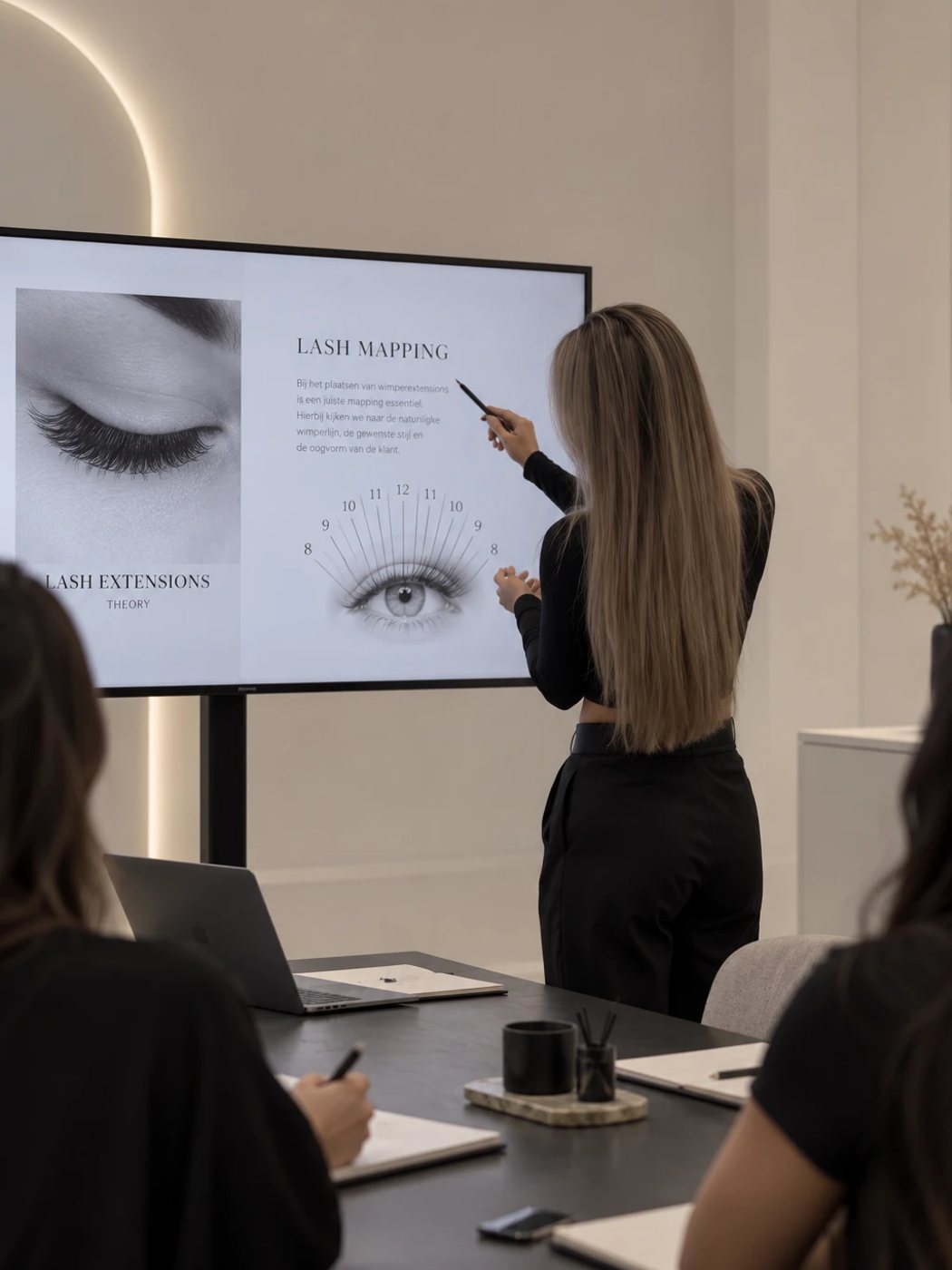 Trainer Wendy legt lash mapping uit op een scherm aan cursisten tijdens de theorieles
